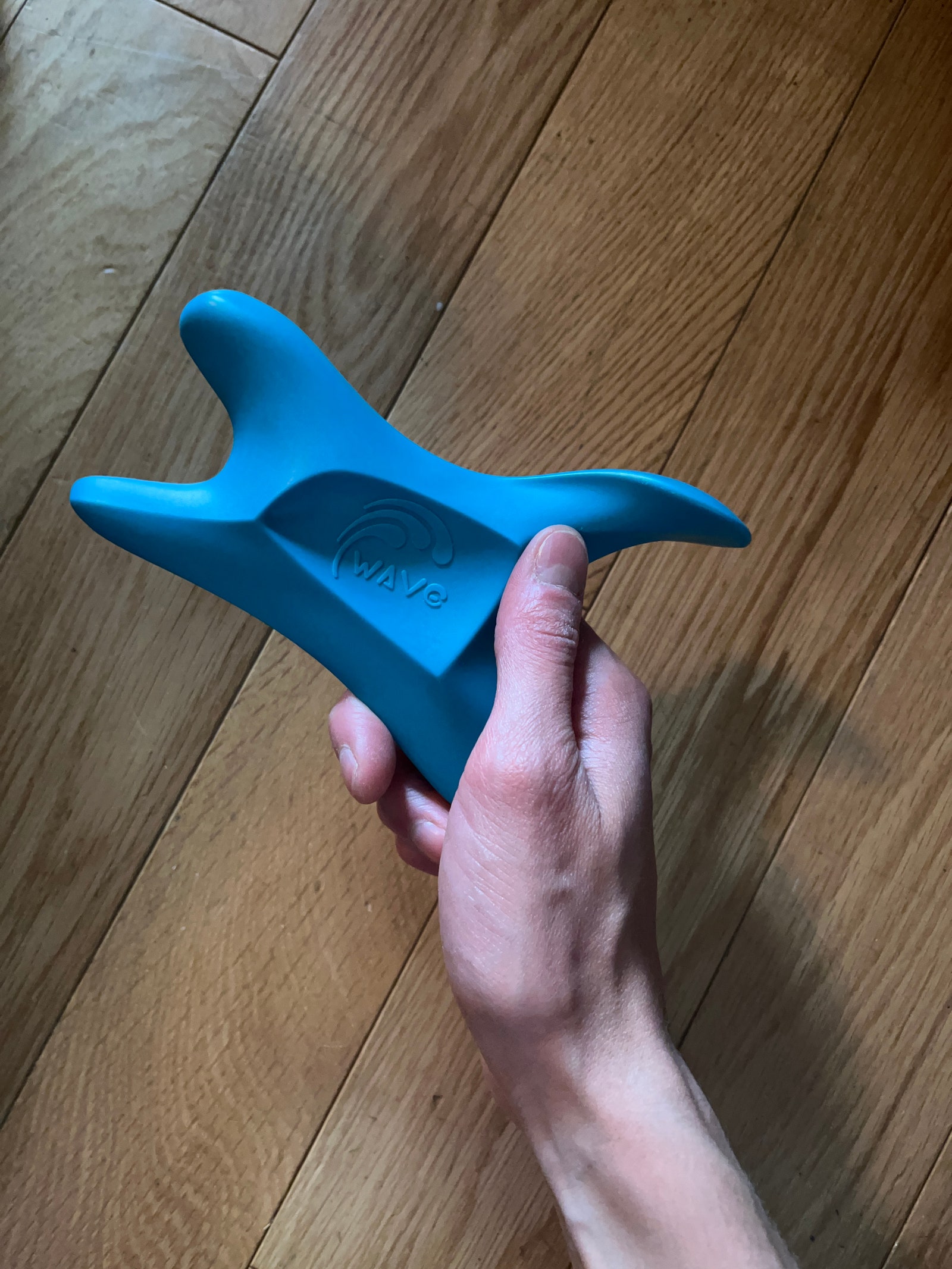 Person holding blue manual massage and scraping tool