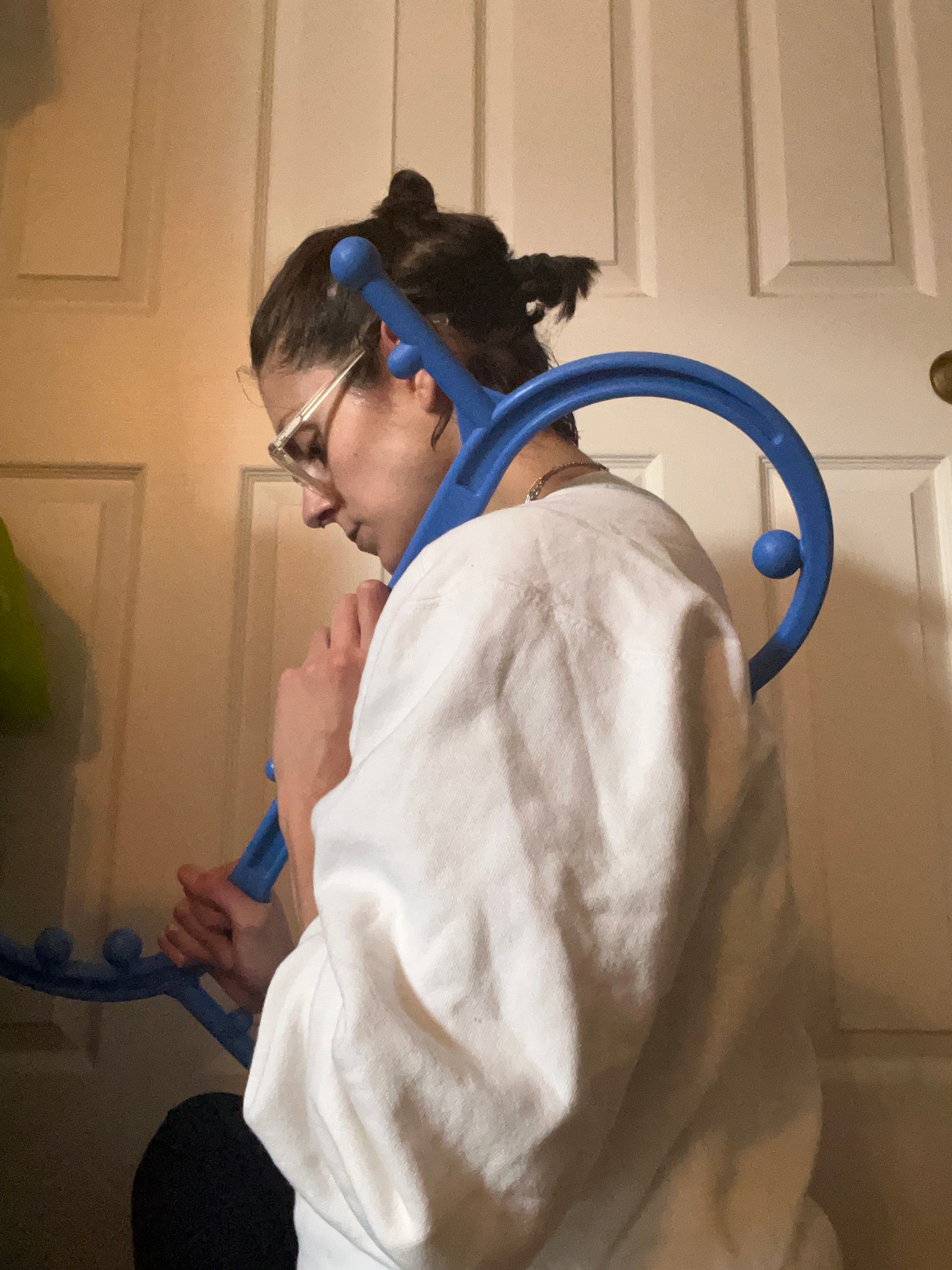 Person using a blue massage cane on their back