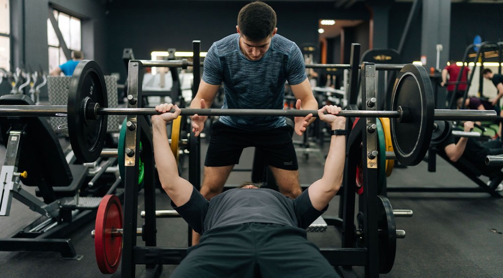 Personal trainer spotting a lifter using the bench press exercise